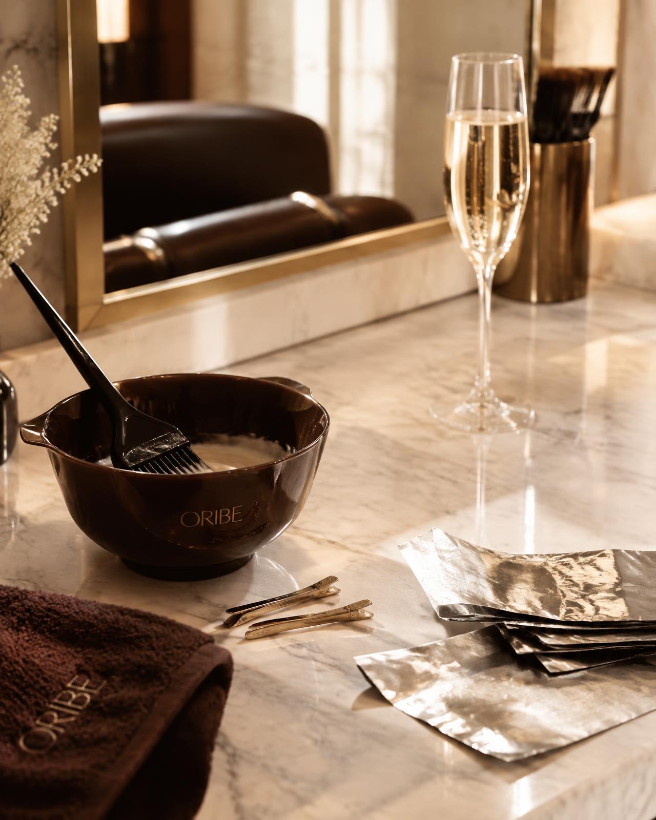 Color bowl, brush and foils on a marble salon counter